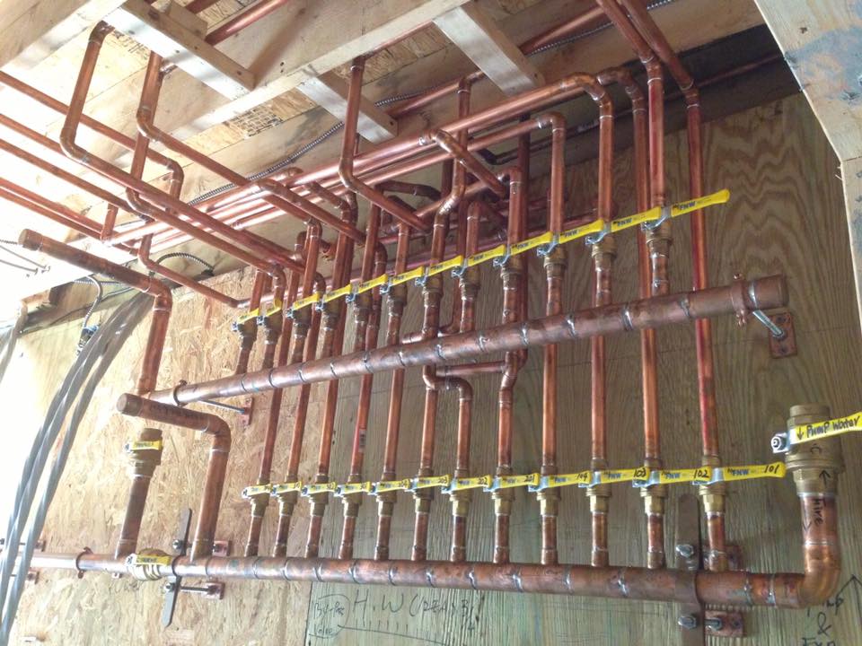 Custom copper water manifold with labeled shut-off valves