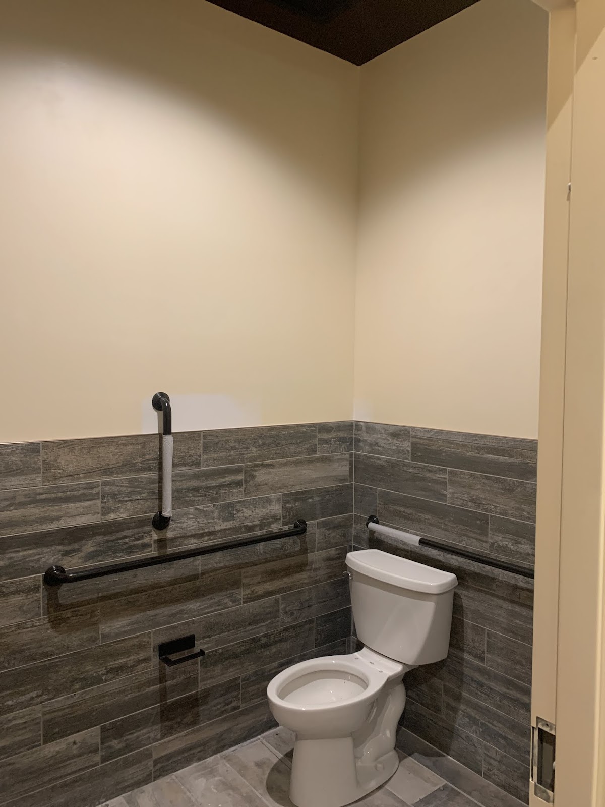 Commercial ADA restroom with wood-look tile and grab bars